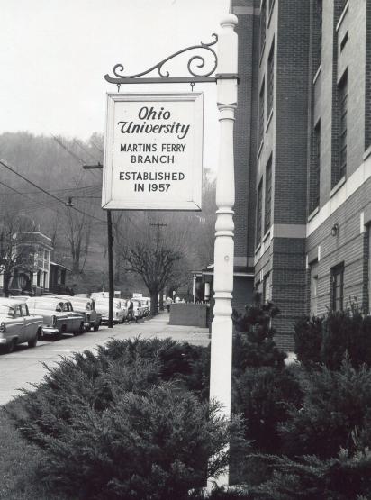 White sign hanging from an ornate post. Sign reads Ohio University Martins Ferry Branch