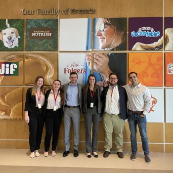Center for Consumer Research and Analytics students pose in front of brands they've worked with