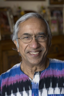 Man smiling into the camera with a colorful shirt on.