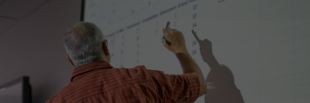 Professor points to data on a white board