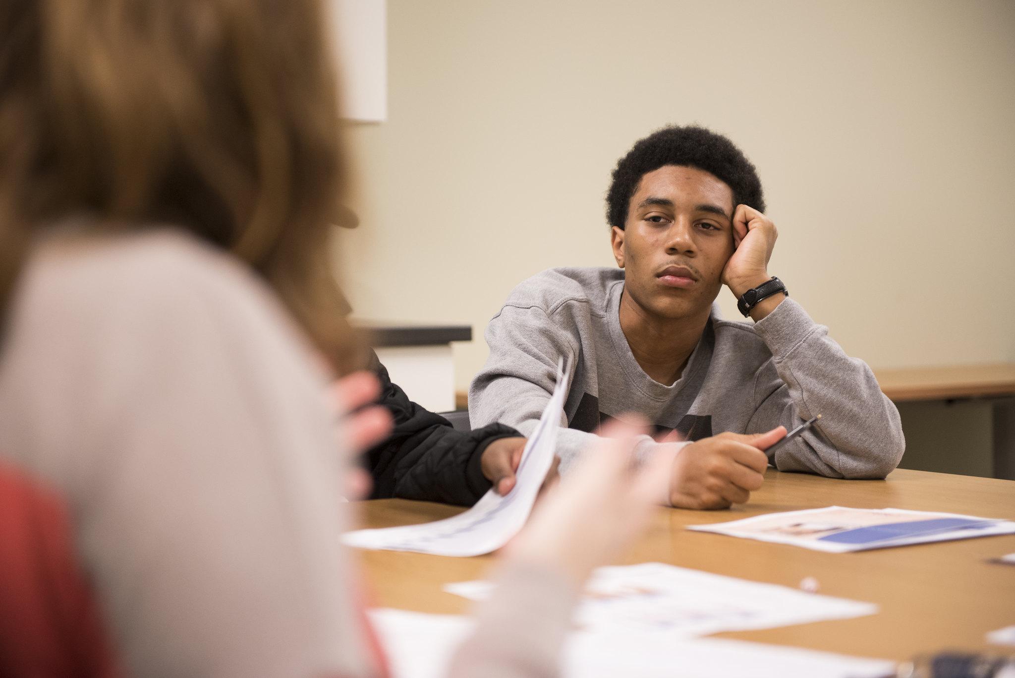 A teen listens to a conversation